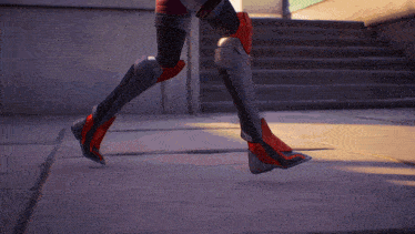 a person wearing a pair of red and black boots is walking on a sidewalk