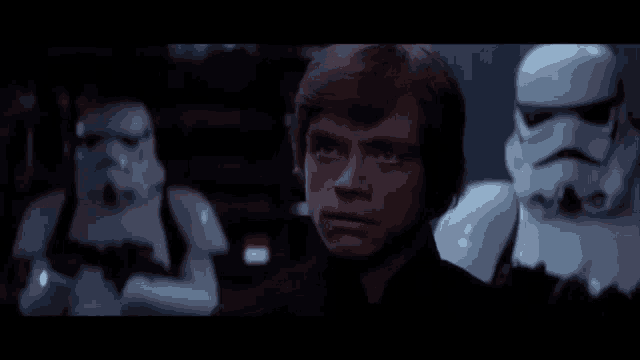 a man in a black shirt is standing in front of stormtroopers