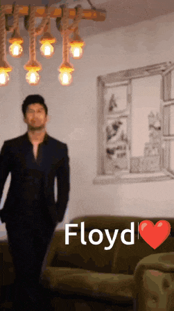 a man in a suit is standing in front of a couch with the name floyd written above him