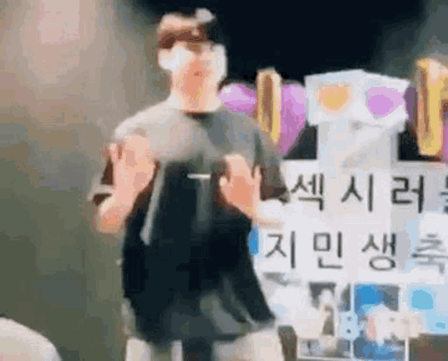 a man wearing a mask is dancing in front of a sign that says `` i love you '' .