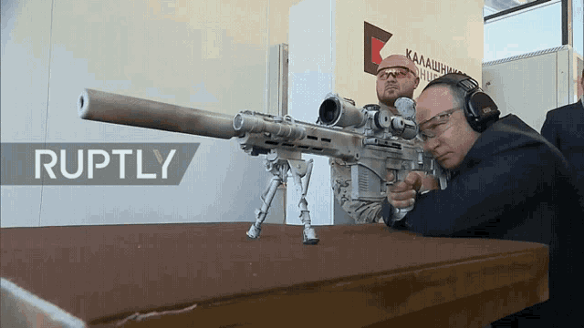 a man holding a rifle in front of a ruptly logo