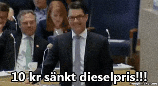 a man in a suit and tie stands in front of a microphone with the words 10 kr sankt dieselpris written above him