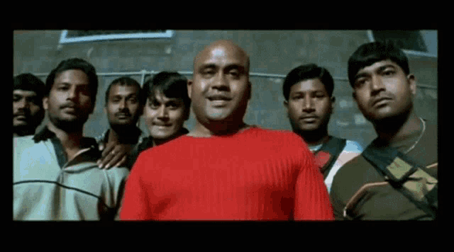 a man in a red sweater is surrounded by other men