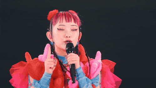 a woman with red hair is holding a microphone in her hand