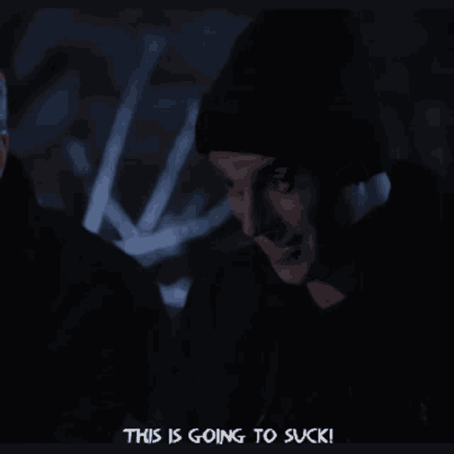 a man in a black hat says " this is going to suck " in a dark room