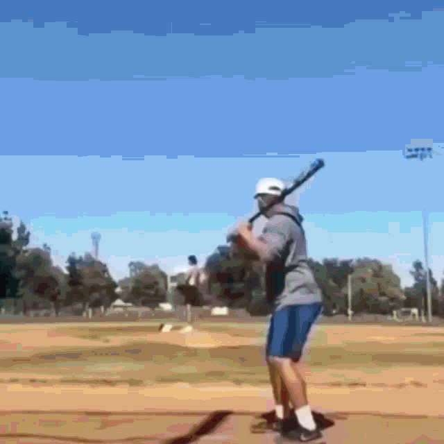 a man is holding a baseball bat on a field