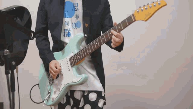 a person playing a guitar with a shirt that says ' a ' on it