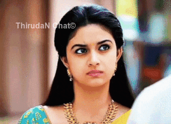 a close up of a woman wearing a necklace and earrings looking at the camera .