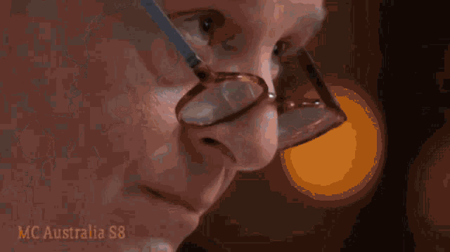 a man wearing glasses looks at something in his hand