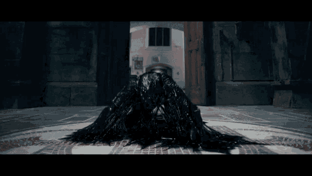 a person covered in black sitting on the floor