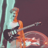 a man is playing a guitar on a stage