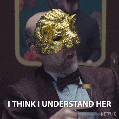 a man with a mask on his face is holding a glass of wine and says i think i understand her