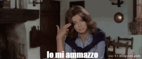 a woman is pointing her finger at her head with the words lo mi ammazzo written above her