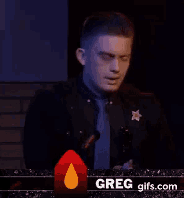 a man in a sheriff 's uniform is standing in front of a microphone .