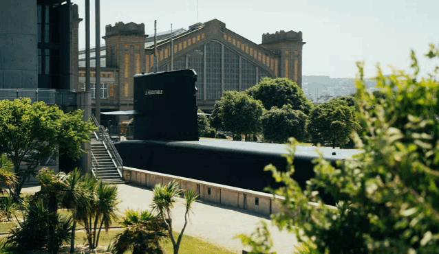 a large black submarine is sitting in a park