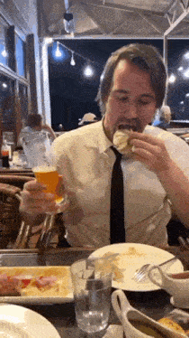 a man sitting at a table with a glass of beer in his hand