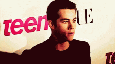 a man is standing in front of a sign that says teen