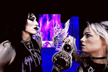 a man and a woman are standing next to each other with a purple background .