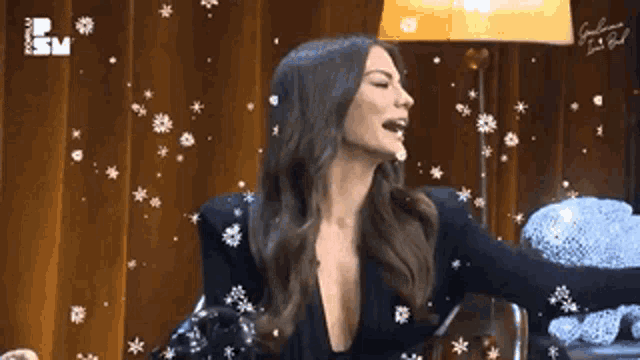 a woman in a black jacket with a plunging neckline is surrounded by snow
