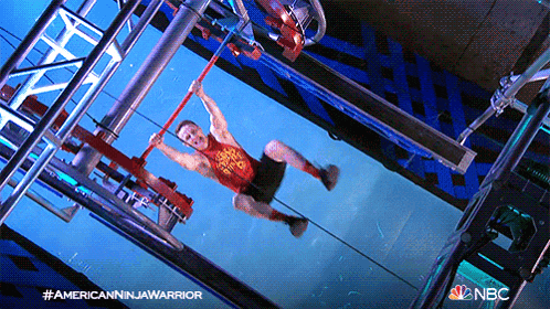 a man in a red tank top is hanging from a rope in a nbc advertisement