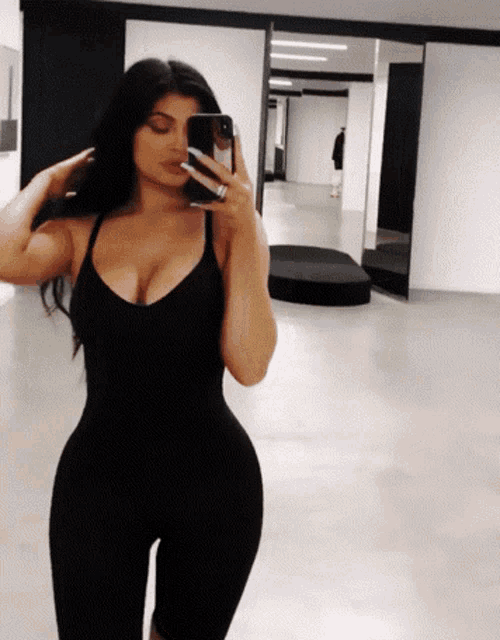 a woman taking a picture of herself in a mirror with her phone