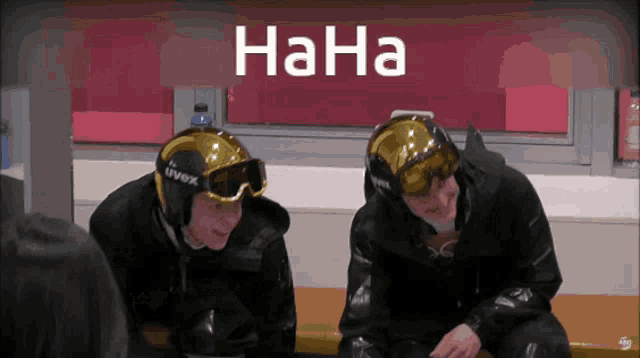 two people wearing uvex helmets and goggles are sitting on a bench