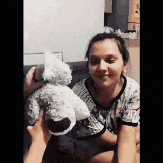 a woman is holding a stuffed animal in her hands .
