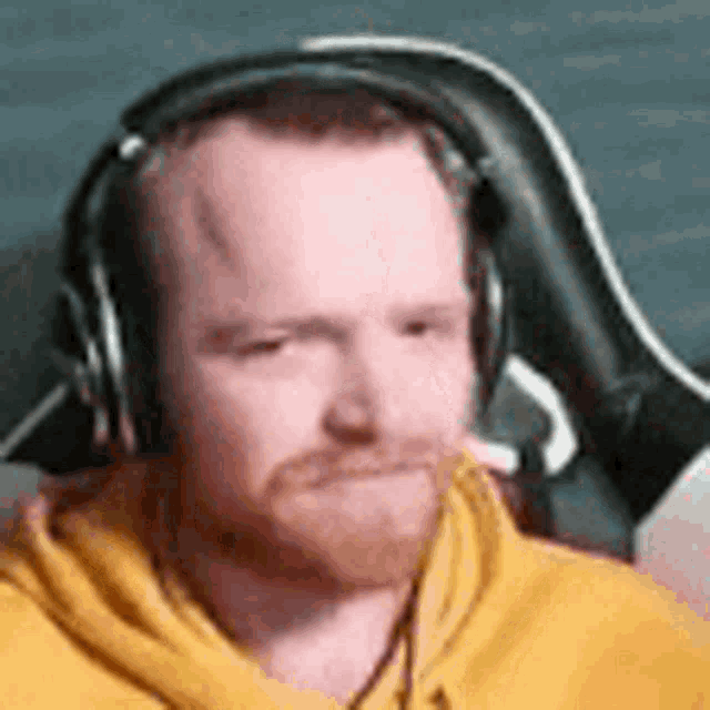 a man with a beard wearing headphones is sitting in a chair .