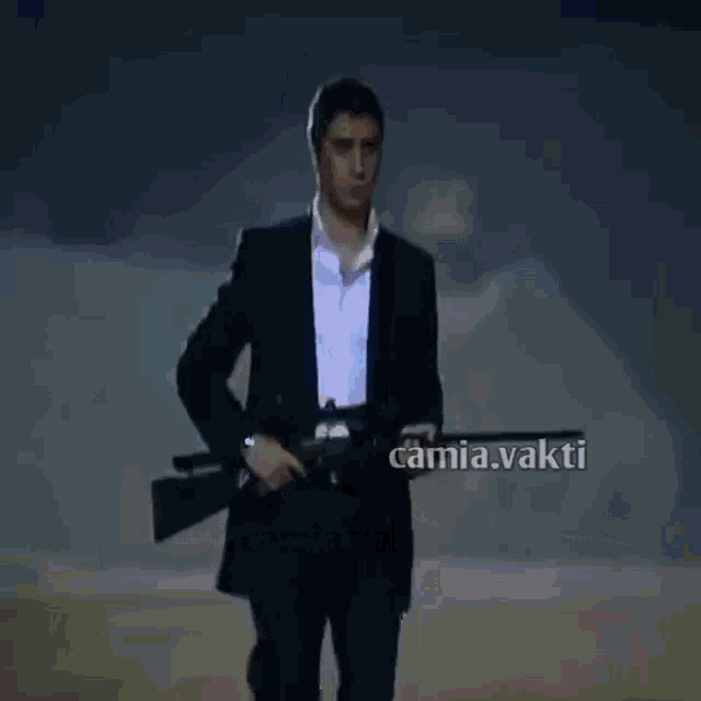 a man in a suit is holding a rifle in front of a camia.vakti banner