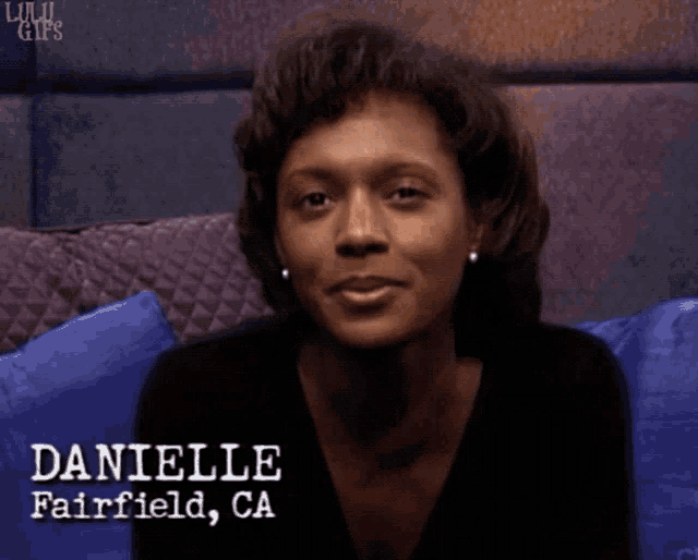 a woman is sitting on a couch and the name danielle is on her face