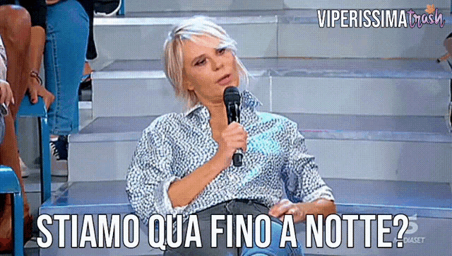 a woman speaking into a microphone with the words stiamo qua fino a notte