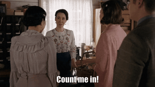 a group of people standing around a table with the words count me in