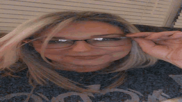 a woman wearing glasses is laying on her back