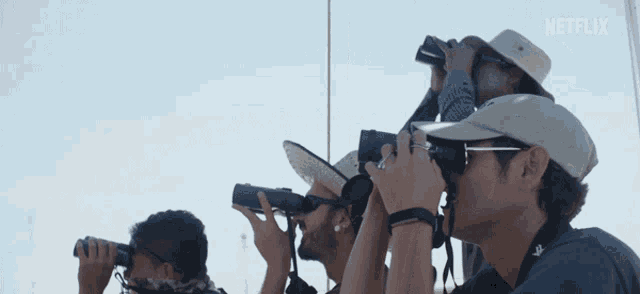 a group of men looking through binoculars with a netflix logo in the corner