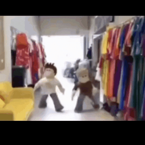 a couple of stuffed animals are dancing in a room with clothes on display .