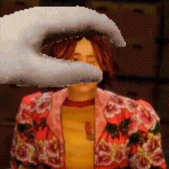 a woman in a floral jacket is being slapped by a hand
