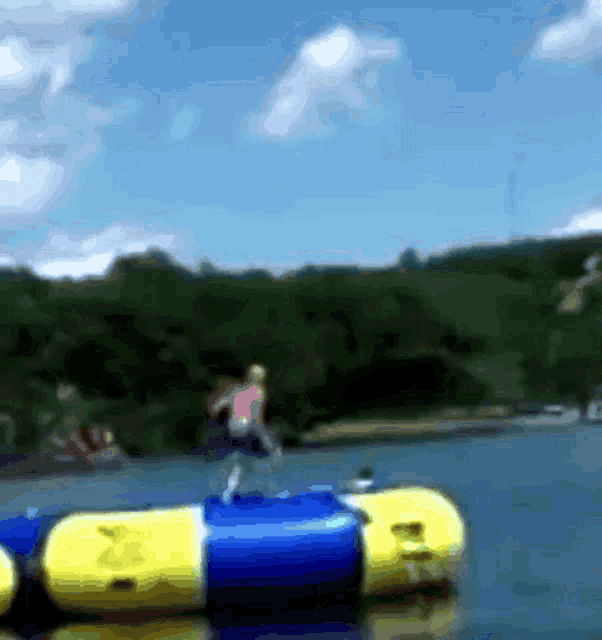 a blurry picture of a person jumping off a raft in the water