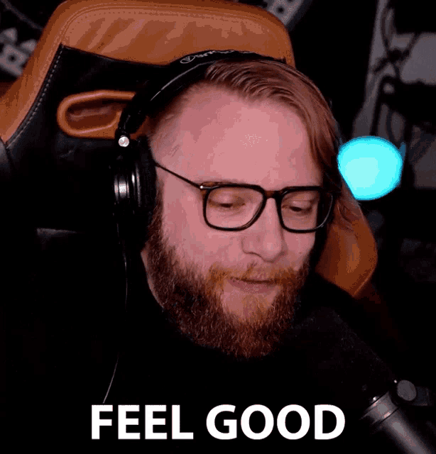 a man wearing glasses and headphones says " feel good " in front of a microphone