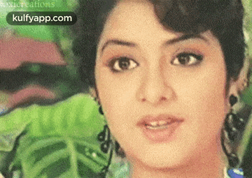 a close up of a woman 's face with a green background and the words kulfyapp.com in the corner .
