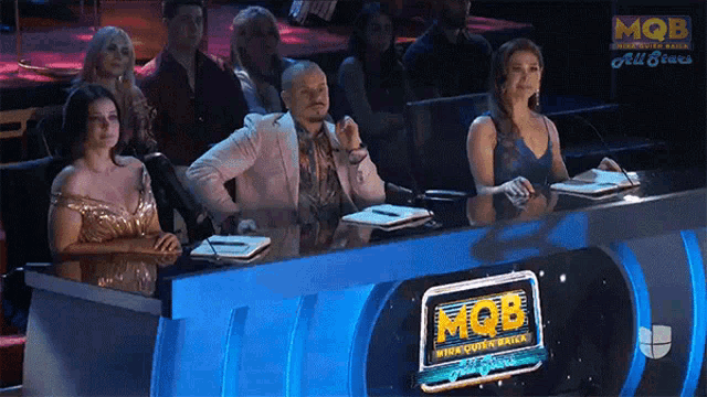 a group of people sit at a table with a sign that says mob on it