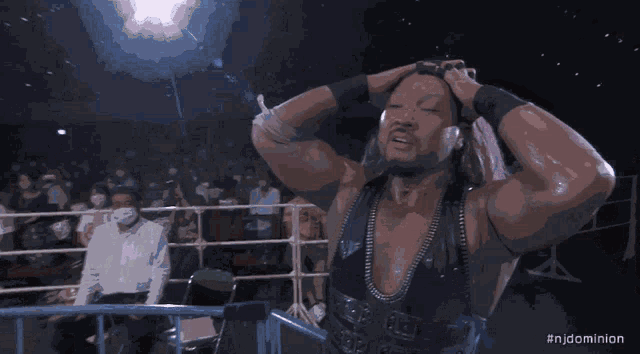 a man is flexing his muscles in front of a crowd with the hashtag #njdominion