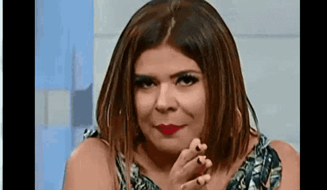 a woman is making a funny face while sitting in front of a window .