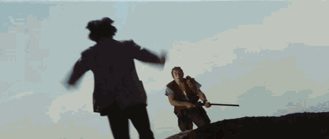 a man in a brown vest is holding a shotgun in his hand