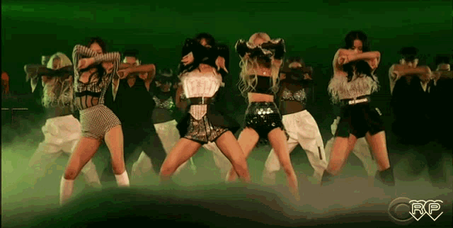 a group of women are dancing in front of a green background with the letters rp on it