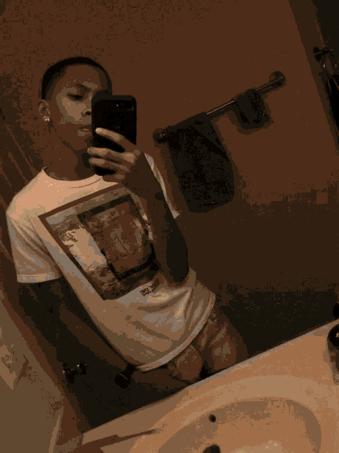 a young man is taking a selfie in the bathroom mirror