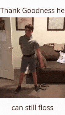 a boy is dancing in front of a couch in a living room with a caption that says thank goodness he can still floss