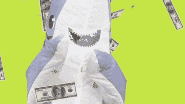 a toy shark is surrounded by money that is falling from the airplane