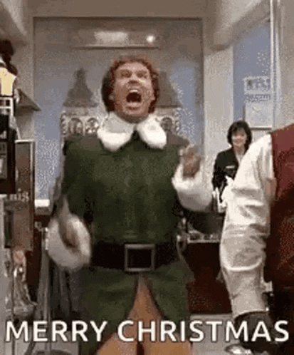 a man in a green elf costume is shouting merry christmas while dancing in a room .