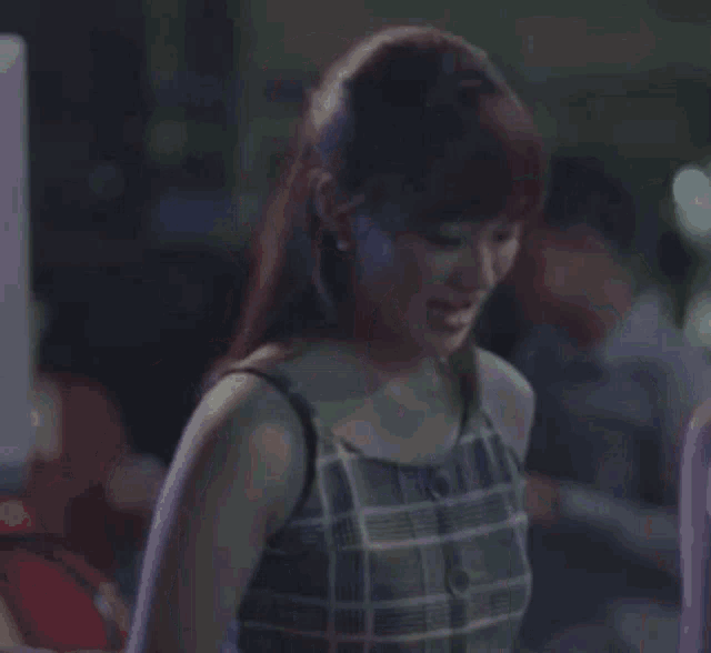 a woman in a plaid top is making a funny face