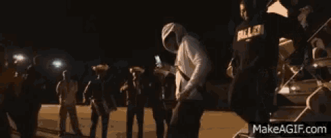a group of men are standing in front of a plane . one of the men is wearing a sweatshirt that says nigger .